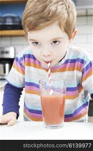 Young Boy Drinking Fruit Smoothie From Glass