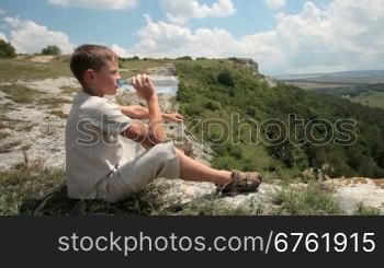 Young boy drinking purified water in the mountain