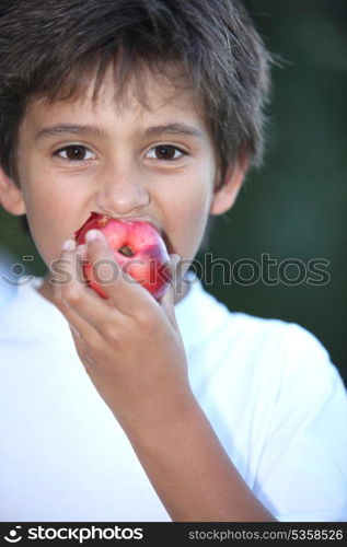 Young boy eating a nectarine