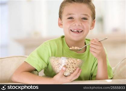 Young boy eating cereal in living room smiling