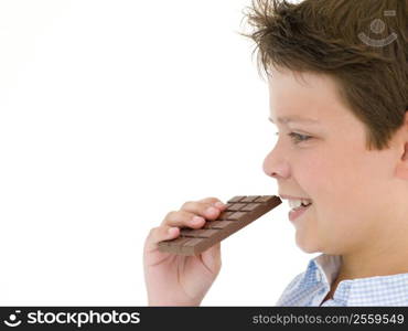 Young boy eating chocolate bar