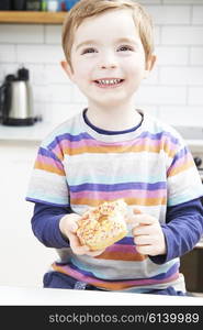 Young Boy Eating Sugary Donut For Snack