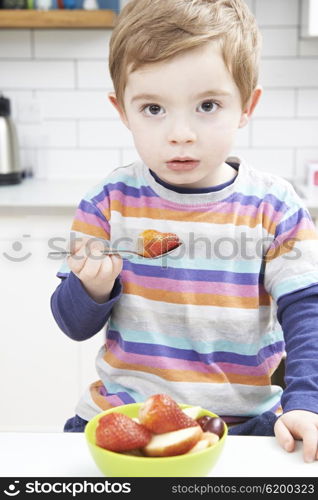 Young Boy Enjoying Healthy Snack Of Fresh Fruit