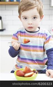 Young Boy Enjoying Healthy Snack Of Fresh Fruit