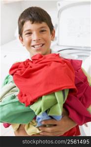 Young Boy Holding A Pile Of Laundry