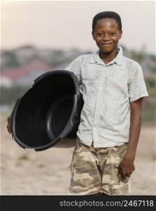 young boy holding basin