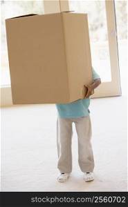 Young boy holding box in new home