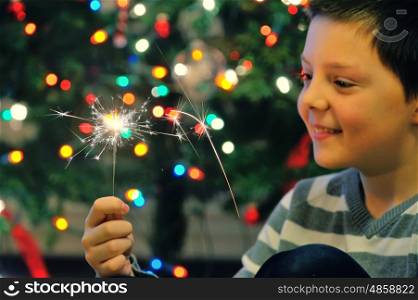 Young boy holding burning sparkler