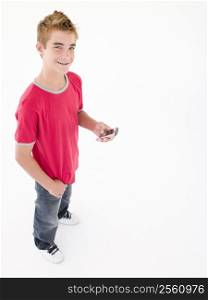 young boy holding cellular phone and smiling