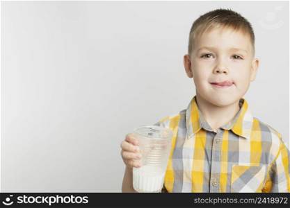 young boy holding glass milk