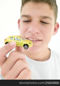 Young boy holding toy car and smiling