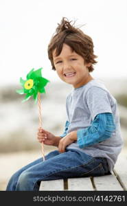 Young boy holding windmill into the wind