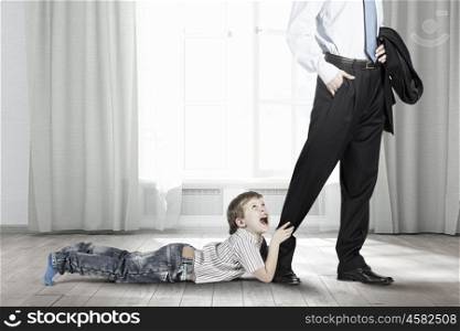 Young boy hugging his father&amp;#39;s leg and crying