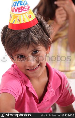 Young boy in a birthday party hat
