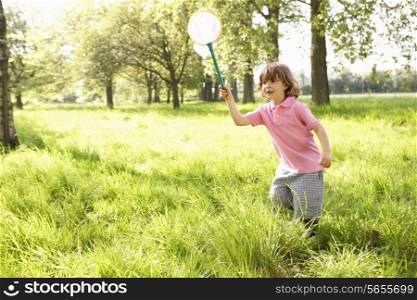 Young Boy In Field With Insect Net