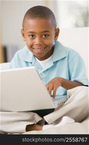 Young boy in living room with laptop smiling
