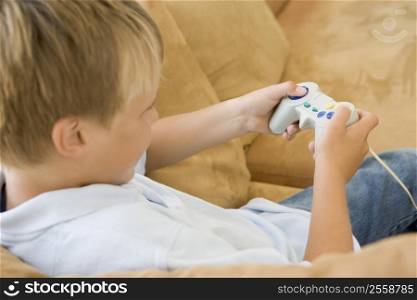 Young boy in living room with video game controller