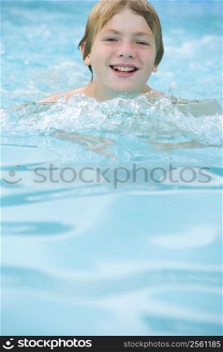 Young boy in swimming pool smiling