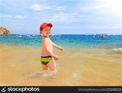 young boy is looking at camera in seaside