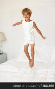 Young Boy Jumping On Bed