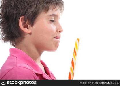 Young boy licking his lips at the sight of his lollypop