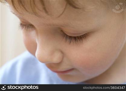 Young boy looks down concentrating
