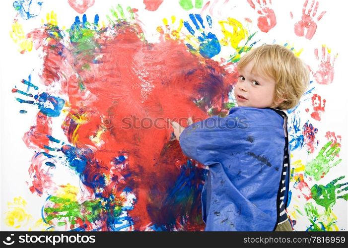Young boy messing about with finger paint