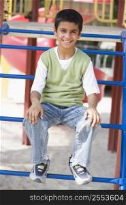 Young boy on playground structure smiling (selective focus)