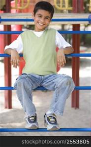 Young boy on playground structure smiling (selective focus)