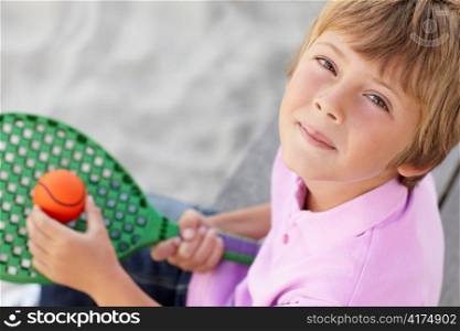 Young boy outdoors with bat and ball