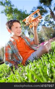 Young Boy Outside Playing With His Toy Model Airplane