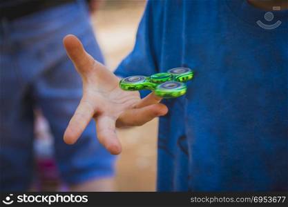 Young boy play with fidget spinner.