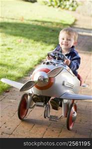 Young boy playing outdoors in airplane smiling