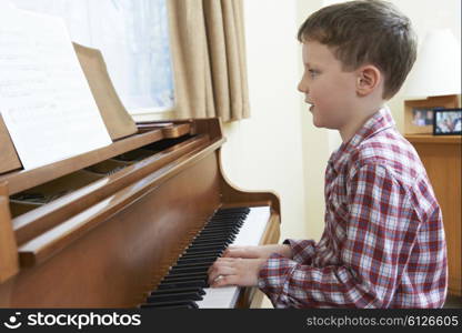 Young Boy Playing Piano At Home