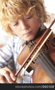 Young Boy Playing Violin At Home