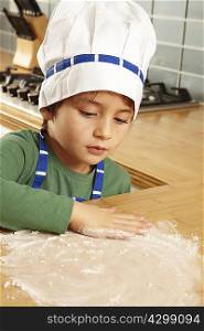 Young boy playing with flour on tabletop