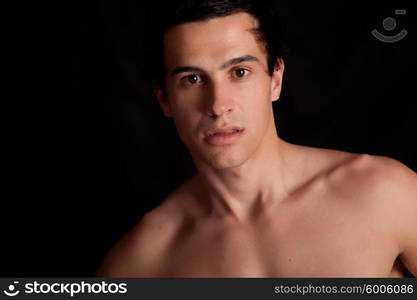 Young boy posing isolated over black background