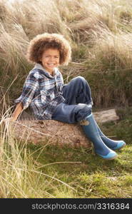 Young Boy Putting On Wellington Boots