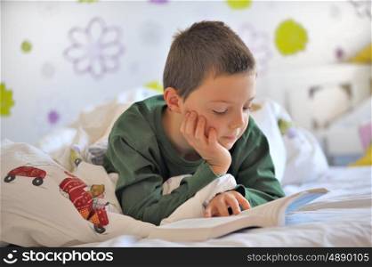 Young Boy Reading a Book in Bed in morning time