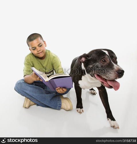 Young boy reading and dog