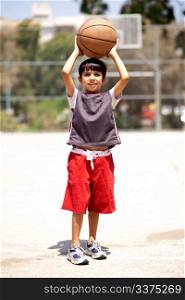 Young boy ready to shot basketball, outdoors