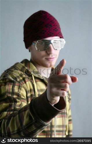 Young boy red cap finger gesture steel glasses over gray background