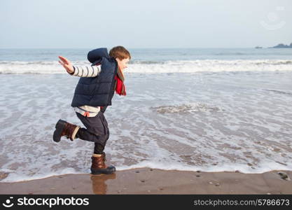 Young Boy Running Along Winter Beach