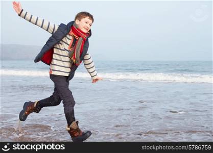 Young Boy Running Along Winter Beach