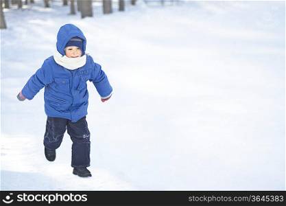Young boy running in the snow