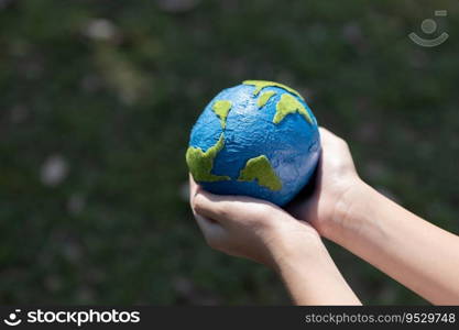 Young boy’s hand holding planet Earth globe at natural park background as Earth day to save this planet with ESG principle and environment friendly energy for brighter future. Gyre. Young boy hand holding planet Earth globe at natural park background. Gyre