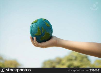 Young boy’s hand holding planet Earth globe with sky and cloudscape background as Earth day to save this planet with ESG principle and environment friendly energy for brighter future. Gyre. Young boy hand holding planet Earth globe with sky background. Gyre