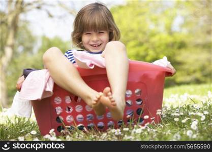 Young Boy Sitting In Laundry Basket
