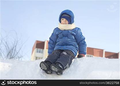Young boy sitting in the snow