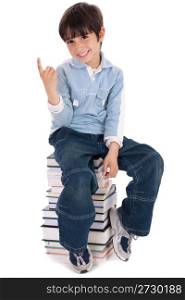 Young boy sitting over tower of books on white background